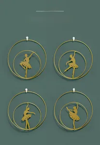Detailed view of 4-piece golden ballet dancer metal wall art on a deep green wall