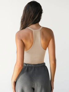 Detail view of beige ribbed racerback sports tank top with seamless back design