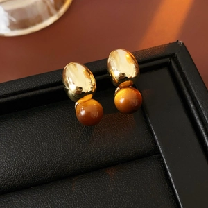 Macro detail of French vintage earrings with gold metal and tiger eye stone beads