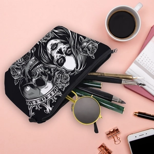 Water-resistant cosmetic bag with skull and rose print on a desk with stationery items
