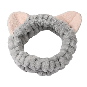 Detail eines flauschigen grauen Katzenohr-Stirnbands mit rosa Innenfutter für die Gesichtsreinigung