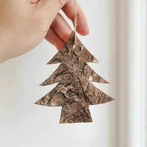 Handcrafted cedar bark Christmas tree ornament with natural texture and rustic hemp rope