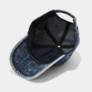 Internal detail of washed denim baseball cap with cotton label and metal buckle