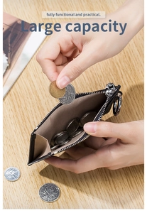 Close-up of placing coins into a black lychee pattern leather wallet with large capacity