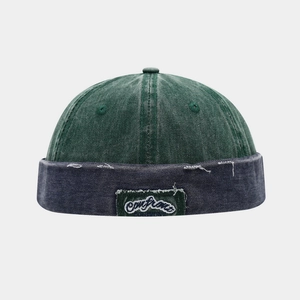 Macro shot of distressed brim edge on vintage forest green and navy denim brimless cap