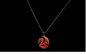 Close-up of a retro glowing dragon totem pendant with red infill and dark metal chain