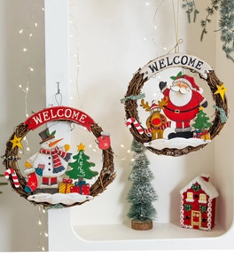 Close-up of Santa and Snowman rattan wreaths with Welcome signs on a festive white wall