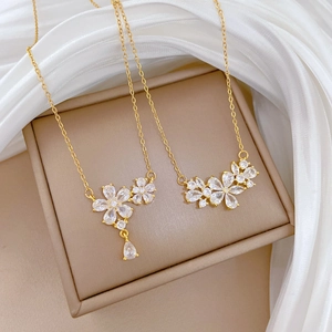Luxurious gold stainless steel floral necklace with zircon crystals on beige velvet box