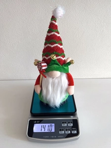Christmas gnome plush decoration on digital scale weighing 141 grams with striped hat