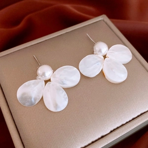 Minimalist pearl flower stud earrings with white shell petals on champagne jewelry box