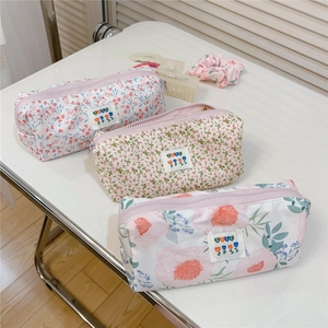 Detailed macro view of three floral cotton pencil cases with zippers and decorative BEST labels