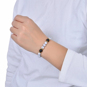 White turquoise and black lava stone beaded bracelet with golden spacers on wrist