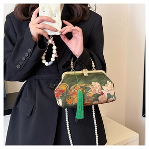 Detail of green floral brocade handbag with vintage metal clasp and pearl chain