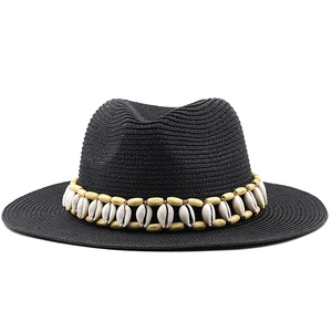 Detail of black straw fedora featuring a bohemian wood bead and shell decorative band