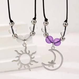 Detalle de colgantes de sol y luna con cuentas púrpuras en cordones negros ajustables