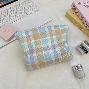 Detailed view of the colorful macaron plaid pattern and woven label on this makeup bag