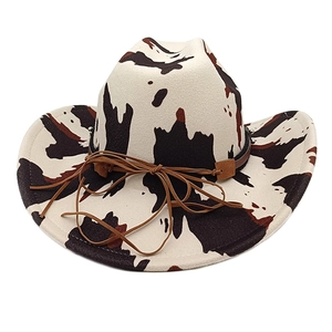Detail view of the felt cowboy hat with cow print pattern and brown leather cord accent