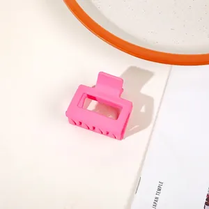 Detail shot of bright pink matte finish square hair claw clip with hollow design