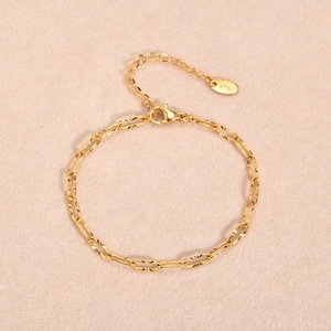 Gold stainless steel paperclip chain bracelet with diamond-cut texture and K18 tag