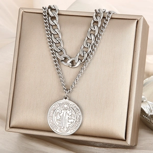 Detail of silver double layer necklace with thick Cuban chain and circular coin pendant
