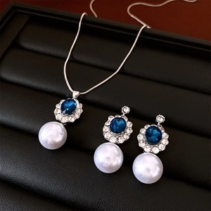 Detail of French style jewelry set featuring blue oval gems with rhinestones and white pearls