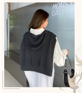 Back view of a thick dark grey hooded knit shawl over a white shirt for winter