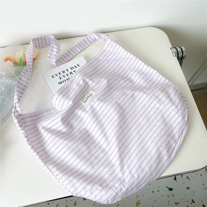 Detail view of light purple striped canvas tote bag with tulips and aesthetic lifestyle items