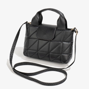 Fashionable black triangular quilted handbag with faux leather strap on white background