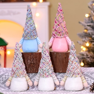 Vue détaillée de gnomes de Noël tricotés colorés avec de longues barbes sur une cheminée