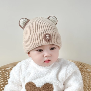 Detail of baby beige knitted hat with cute bear ears and plush fleece lining