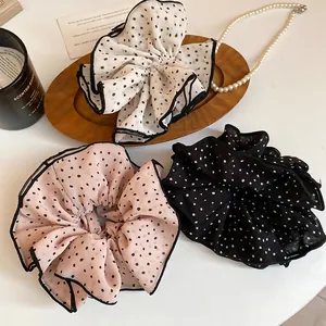 Set of three polka dot chiffon scrunchies in white, pink, and black with delicate black piping