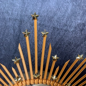Detail of gold star sunburst headband with metallic zip tie spikes and star accents