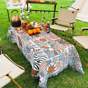 Detailed close-up of Bohemian sun pattern weave and tassels on a thick picnic blanket