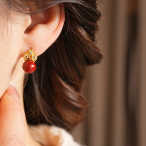 Macro shot of vintage red bead earrings with gold filigree and sparkling zircon crystals