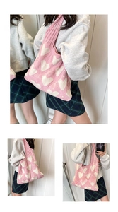 Detail of pink knitted shoulder bag with white heart jacquard pattern and wide strap