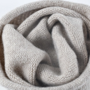 Vue macro d'un bonnet en laine beige montrant une texture de fibre chaude et épaisse