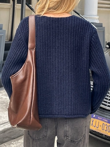 Sac bandoulière en cuir marron chic avec un pull en maille bleu marine pour une tenue d'automne