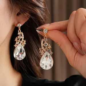 Élégantes boucles d'oreilles dorées avec cristal en goutte et accents brillants