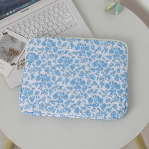Detail of blue floral quilted laptop sleeve with dual metal zippers and soft fabric
