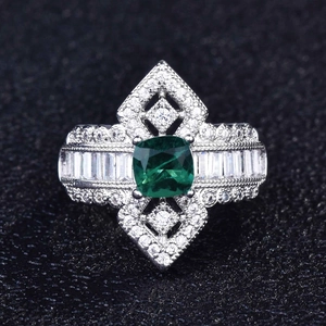 Detailed macro view of pear-shaped green Paraiba gemstone ring with micro-paved diamonds