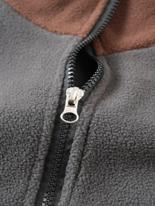 Detail of silver metal zipper and dual-tone gray and brown fleece fabric texture