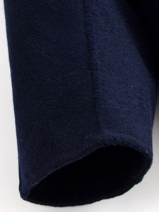 Detailed close-up of navy blue wool coat cuff showing texture and sewing craftsmanship