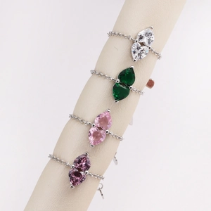 Close-up of heart and pear-shaped colorful zircon chain rings in silver finish