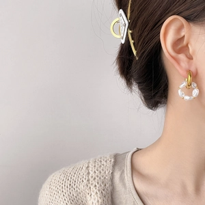 Detailed view of elegant baroque pearl hoop earrings with gold finish on a model