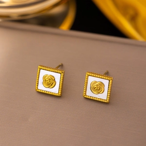 Detailed macro view of vintage square gold rose earrings with white shell inlay