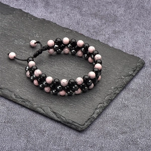 Macro detail of triple-layer braided bracelet with pink turquoise and black beads