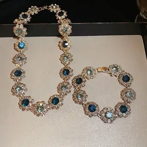 Vintage gold necklace and bracelet set featuring blue flower motifs and crystals