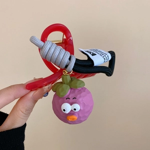 Close-up of a red translucent hair claw clip with a cute purple mangosteen cartoon pendant