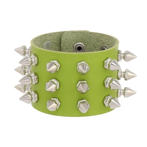 Macro detail of lime green PU leather cuff with triple rows of silver metal cone spikes