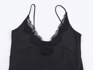 Detail of black satin camisole featuring delicate lace trim and v-neckline texture